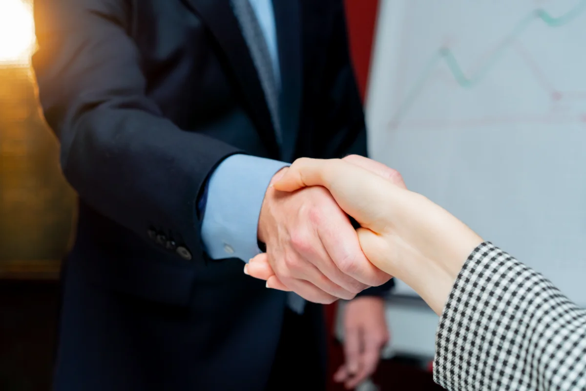 close-up in office against the background of red walls handshake
